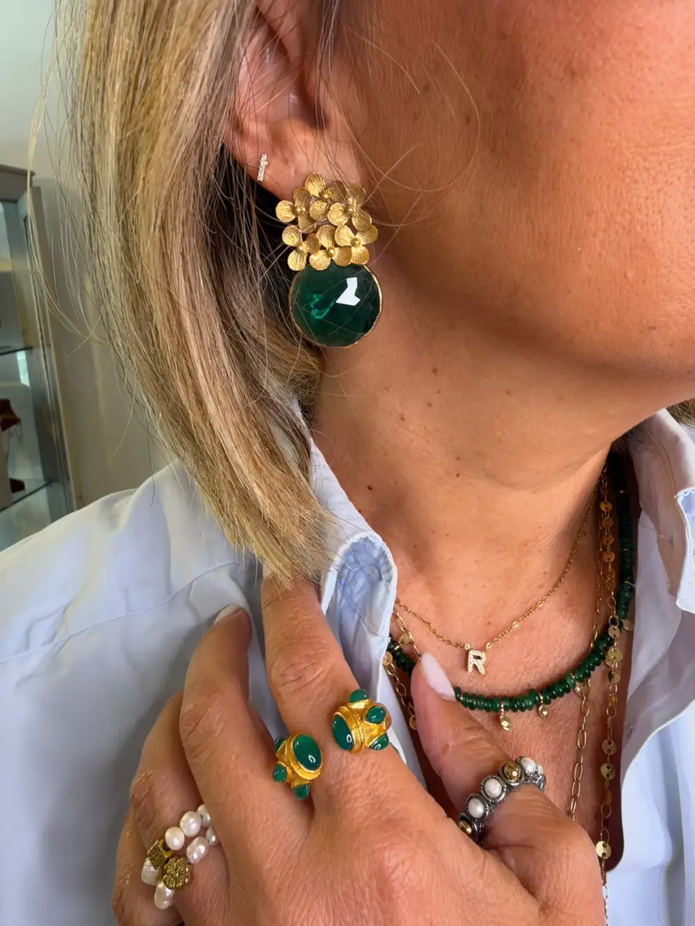 Prata dourada, flores delicadas e pedra verde facetada. Uma peça elegante e marcante que dá um toque de sofisticação a qualquer look.